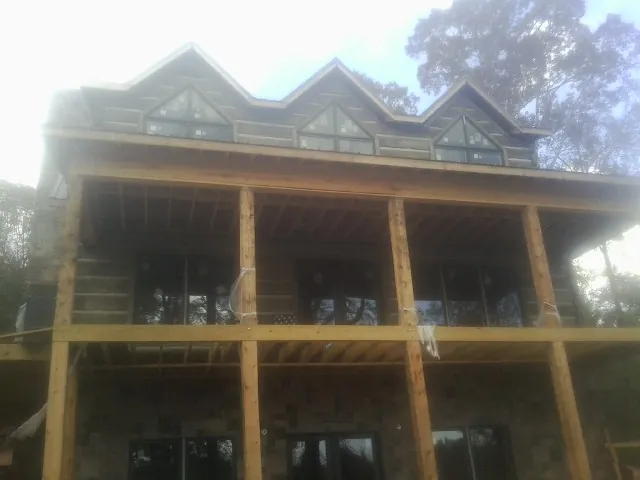 Dormers and porch framing on a large log home under construction — Roof Coating work by our crew in Dahlgren