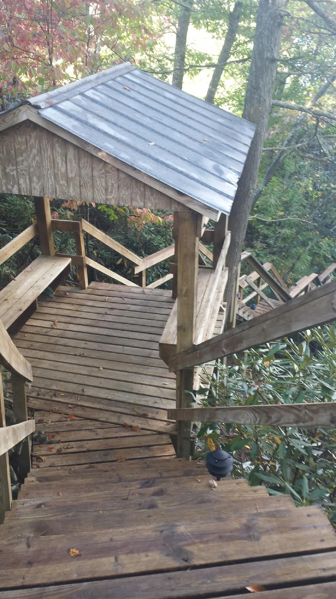 Metal roofed shelter over wooden steps on a wooded walkway — Skylight Repair & Installation work by our crew in Dahlgren