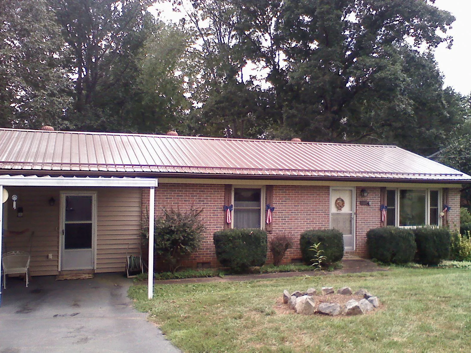 Bronze metal roof and carport on a brick ranch home — Roof Repair work by our crew in Dahlgren